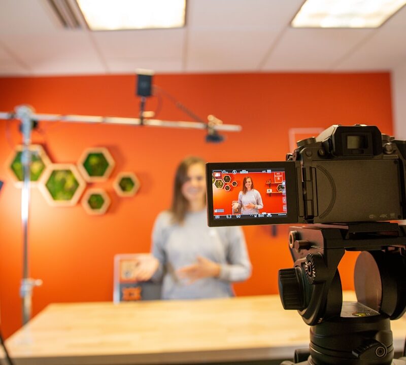 black video camera on brown wooden table