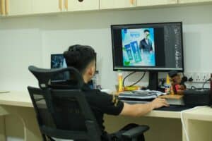 A man sitting at a desk in front of a computer monitor