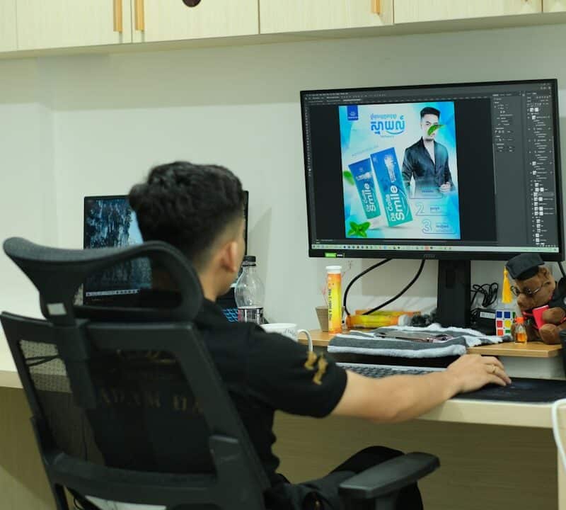 A man sitting at a desk in front of a computer monitor