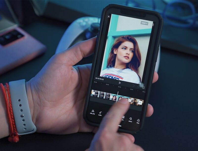 a person holding a cell phone with a picture of a woman on the screen