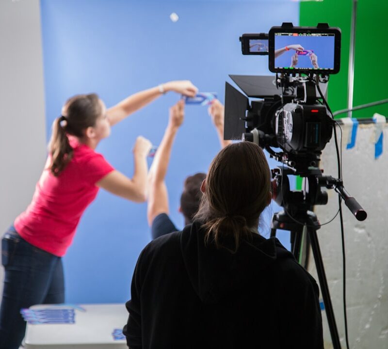 woman in pink long sleeve shirt holding black video camera