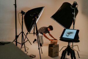 A man setting up boxes in front of a professional video production setup