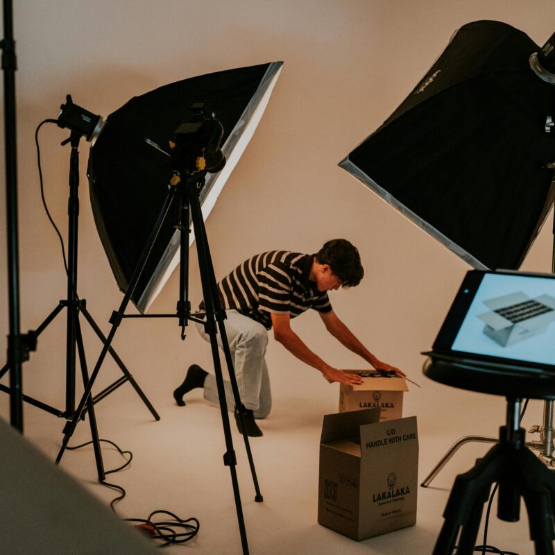 A man setting up boxes in front of a professional video production setup