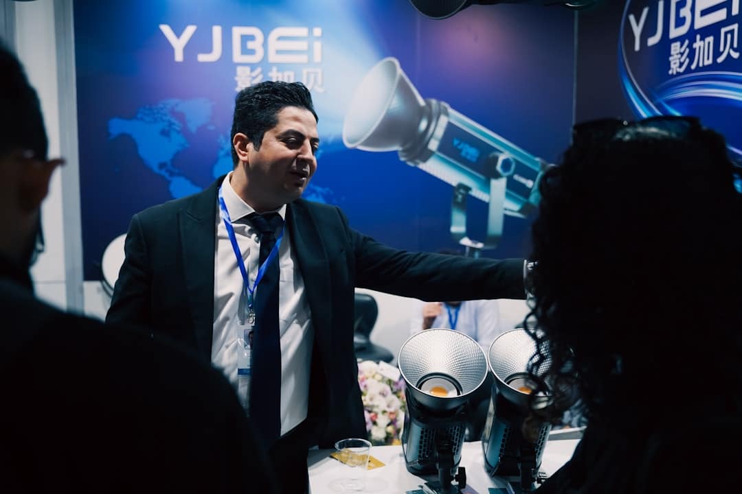 Man in suit presenting equipment at a trade show.