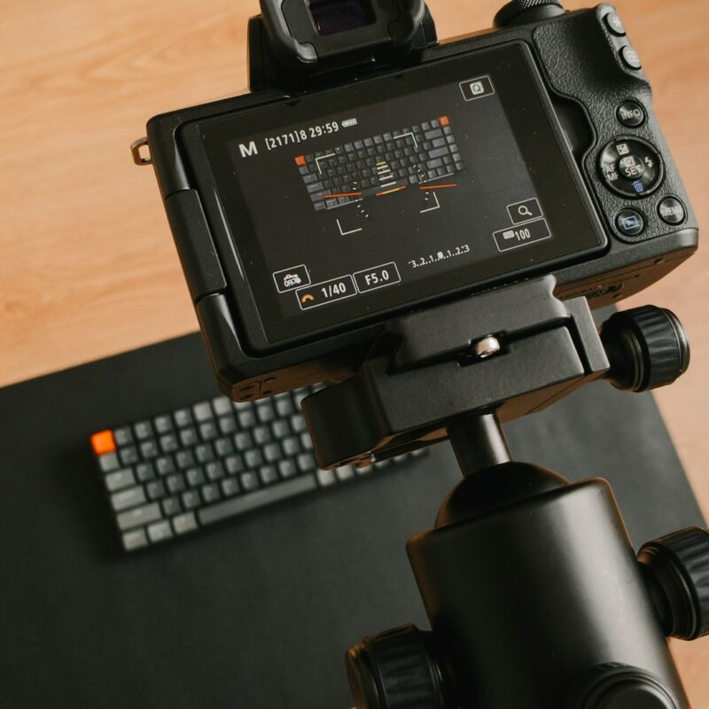 black video camera on black tripod