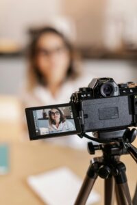 Woman in glasses being filmed with a professional camera