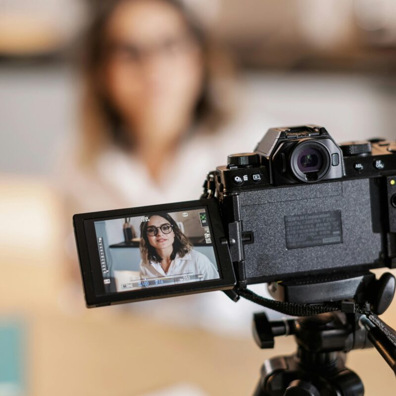 Woman in glasses being filmed with a professional camera