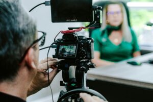 Cameraman recording a woman in a green shirt