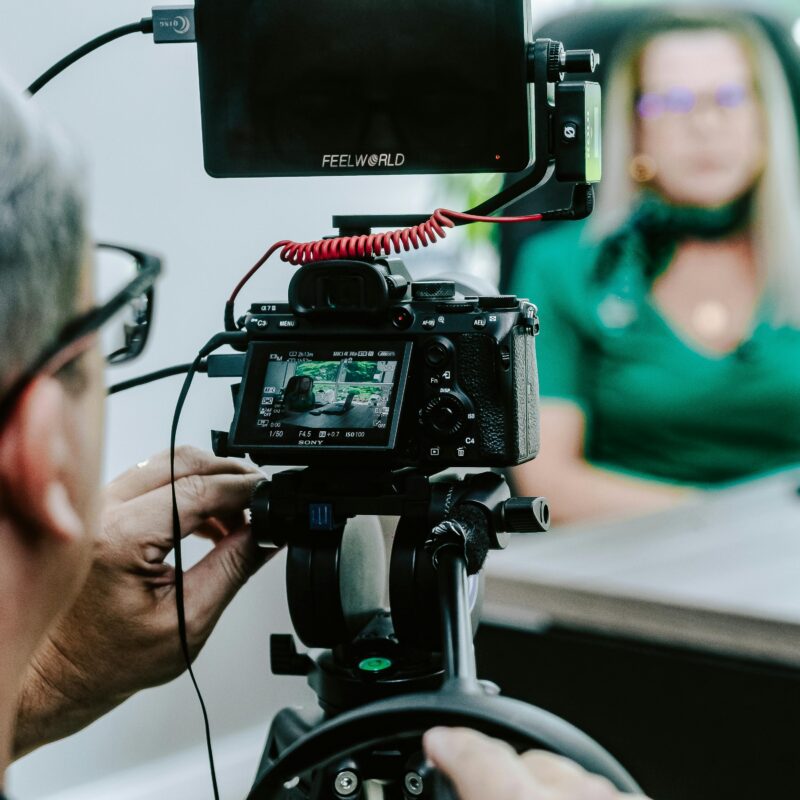 Cameraman recording a woman in a green shirt