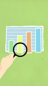 Hand holding a magnifying glass hovering over a bar graph